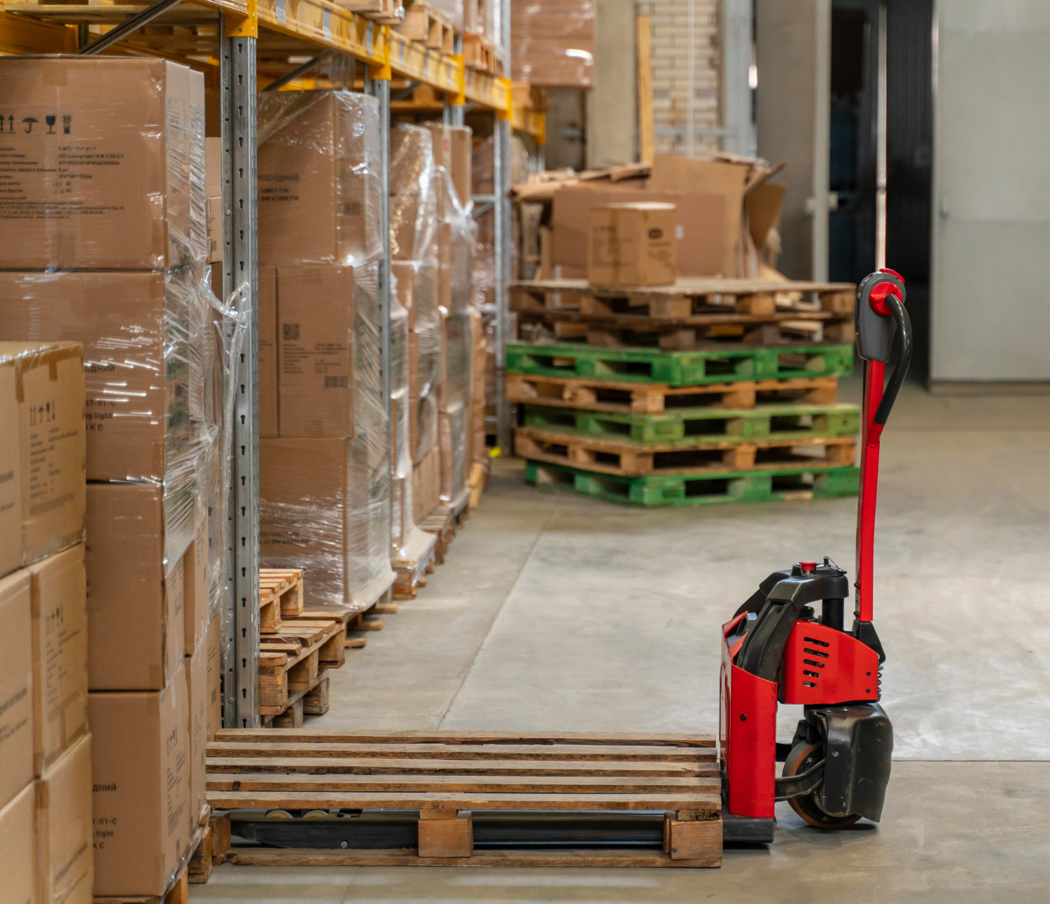 pallet truck under pallets in warehouse 